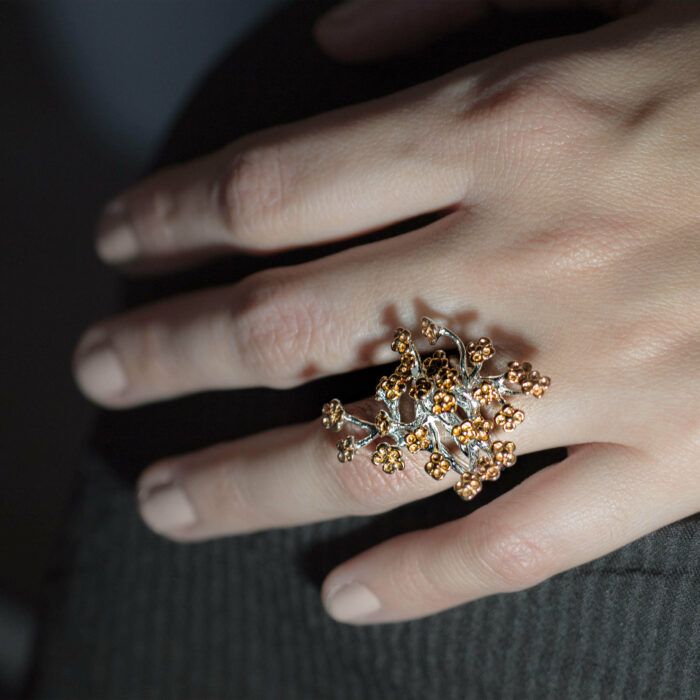 hand wearing gold plated 925 sterling Silver coral sclerites ring from luxury collection to support research and monitoring