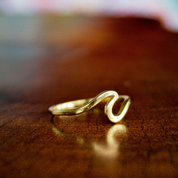 gold color silver ring shaped like a wave to help support research and conservation in the ocean environment